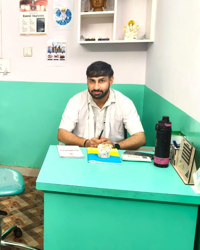 Dr. Vikas Vashisth at his desk in the Swastik Smile Care clinic
